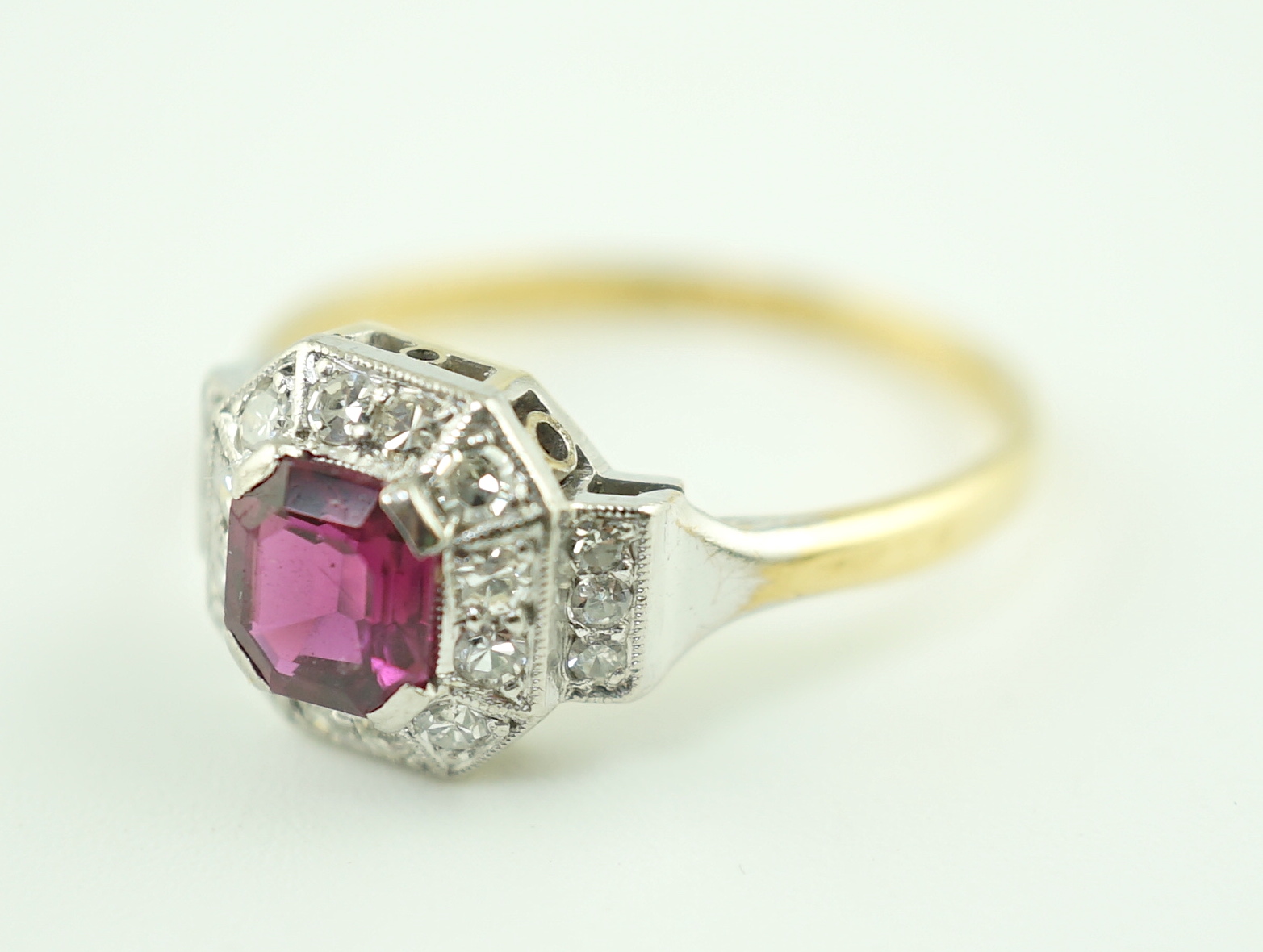 A 1950's Art Deco 18ct gold and platinum, ruby and millegrain set diamond octagonal cluster ring